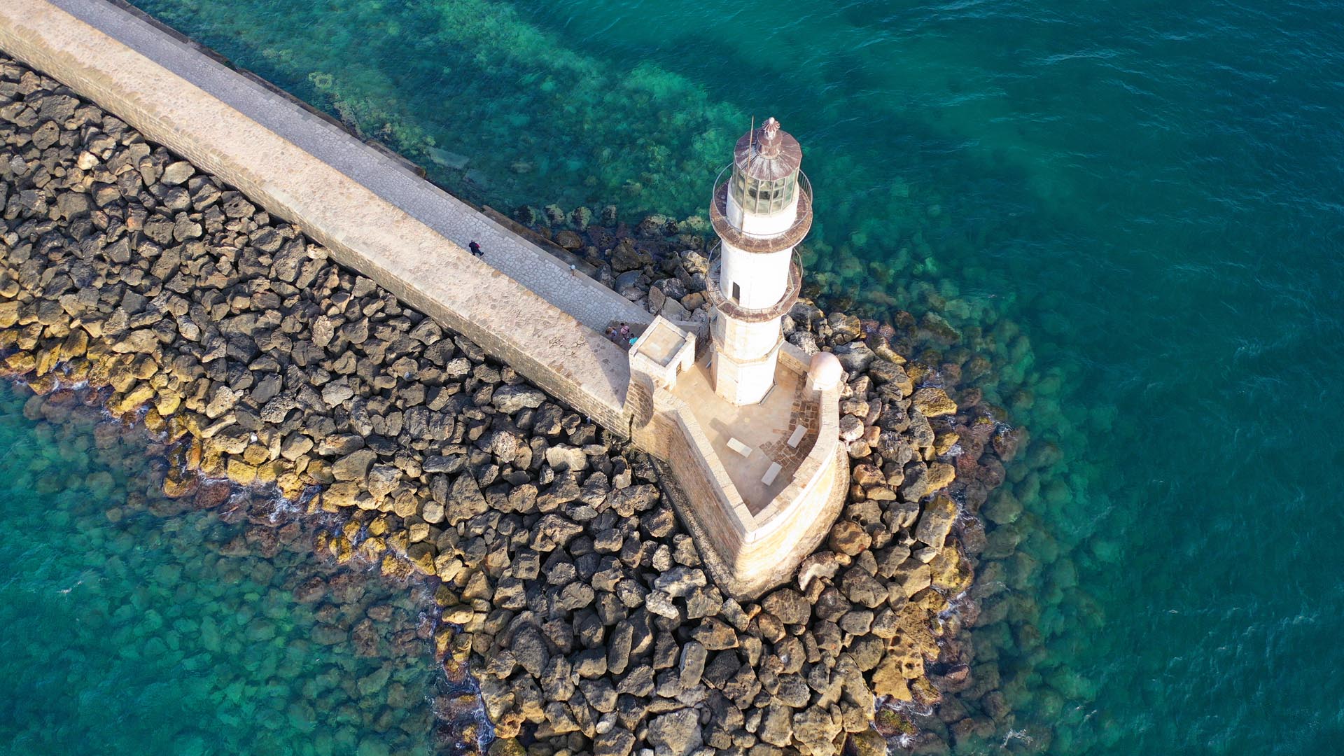 Kouvalite Car Rental | Rent a Car Herkalion, Crete aerial drone photo of iconic Venetian Lighthouse in the entrance of the picturesqueold port of Chania at susnet with beautiful colours