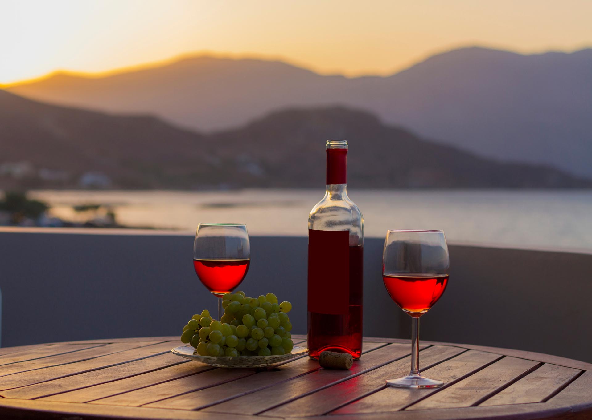 Kouvalite Car Rental | Rent a Car Herkalion, Crete picture of wine in romantic sunset frtom the balcony with mountains view